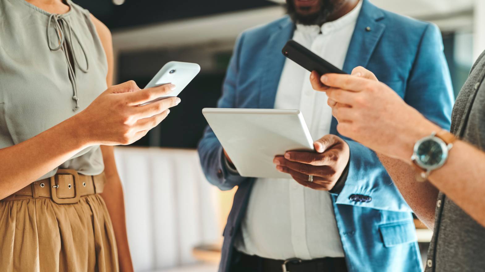 Small crowd of well-dressed people looking at their mobile devices