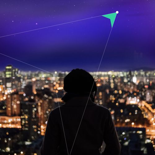 person looking out onto a city and a triangle line shape